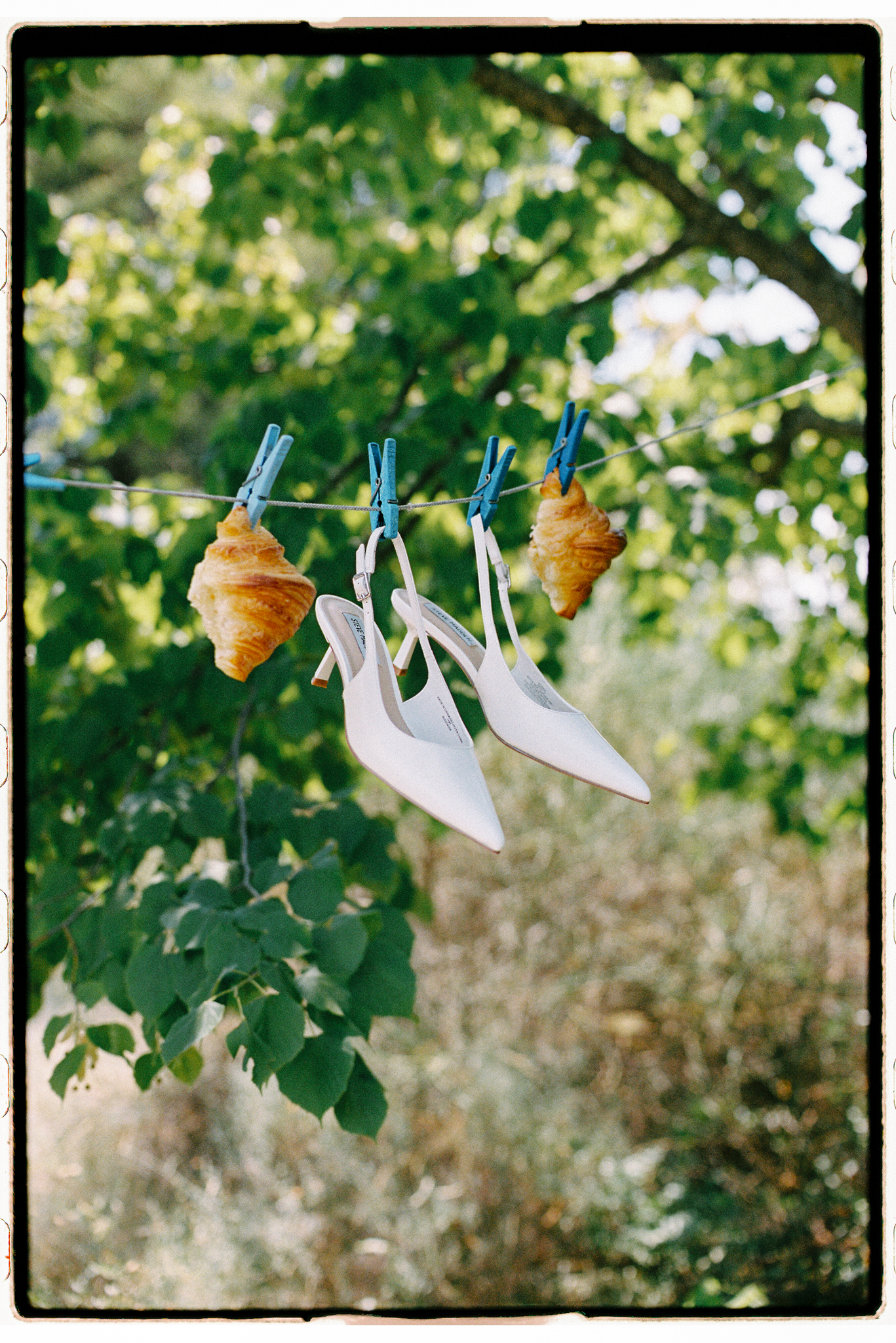 Wedding shoes and croissants hanging in a garden in Provence